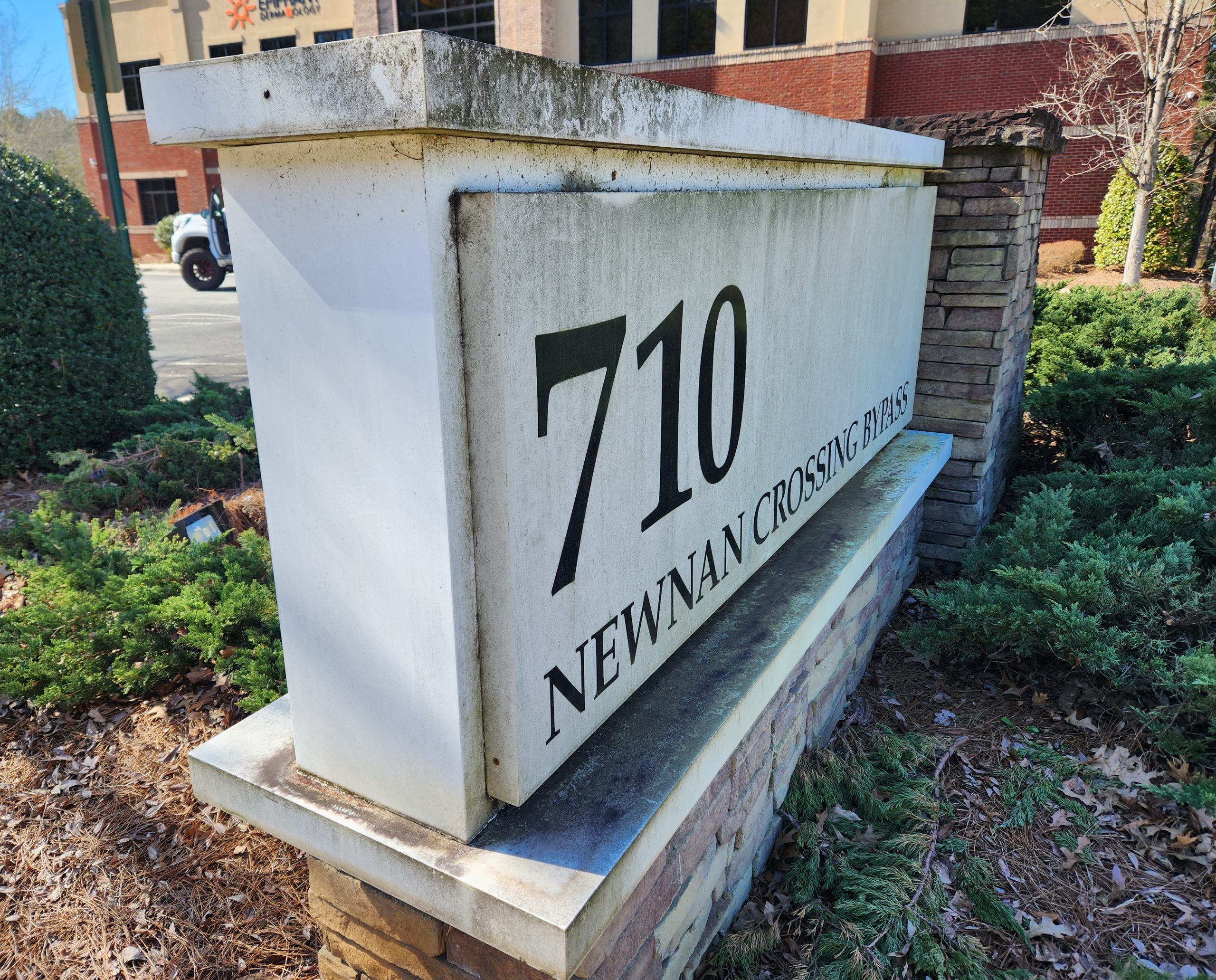 Commercial monument sign with algae and stains before cleaning