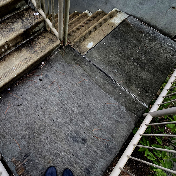 Dirty concrete walkway before pressure washing