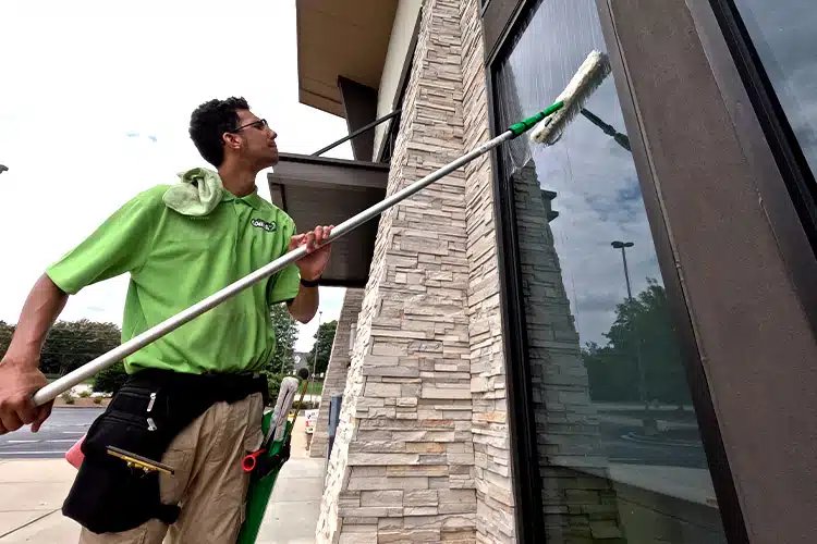 Cleaning Plus technician cleaning commercial windows